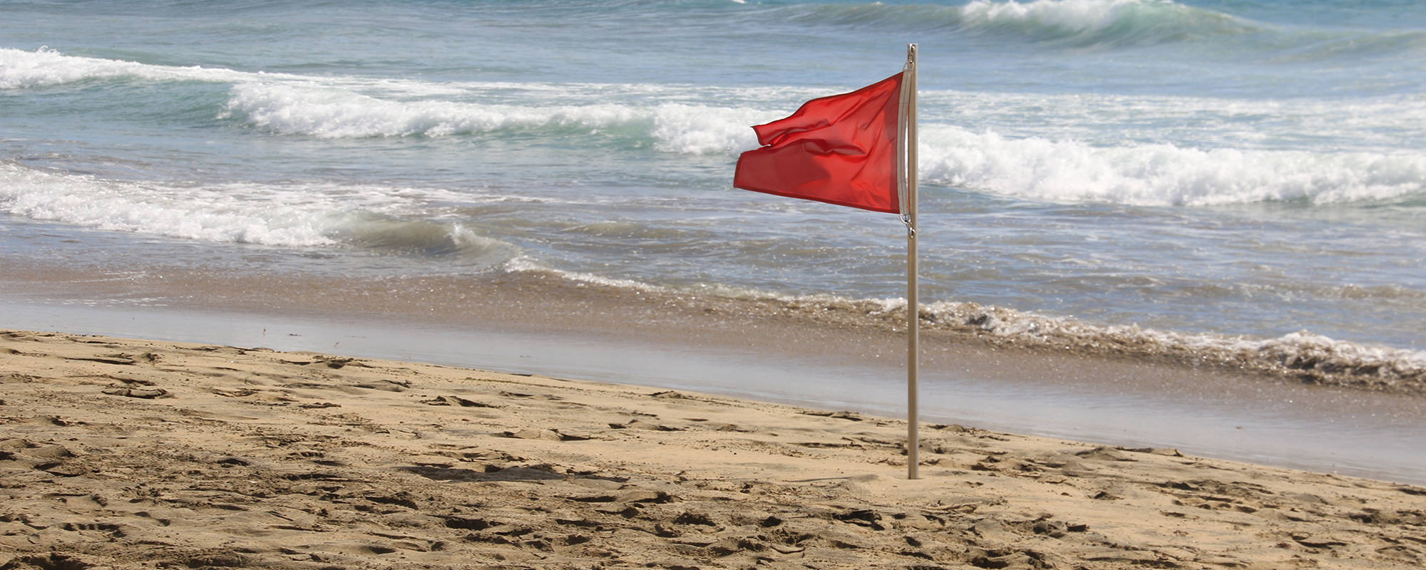 Strand mit roter Flagge